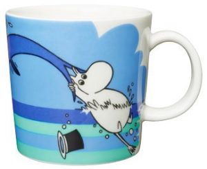 Muumimuki kesäisellä sinisävysellä teemalla, jossa Muumipeikko pitää kiinni delfiinin pyrstöstä.