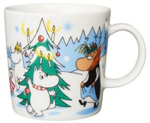 Talviaiheinen Kuusen alla -muumimuki, jossa Muumipeikko, Niiskuneiti ja Hemulitäti tanssivat kuusen ympärillä.